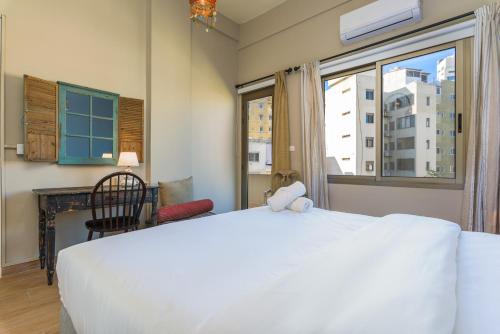 a bedroom with a white bed with a teddy bear on it at 961 Station Apartments in Mar Mikhael in Beirut