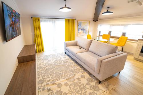 a living room with a couch and a table at First Apartments in Focşani