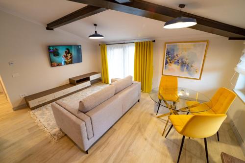a living room with a couch and a table and chairs at First Apartments in Focşani