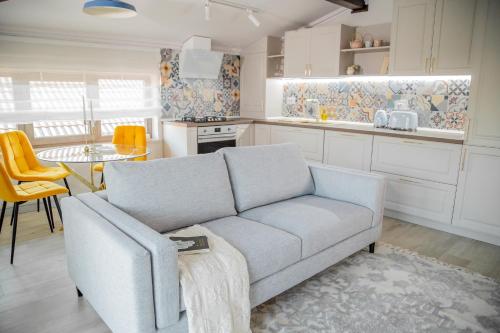 a living room with a couch and a kitchen at First Apartments in Focşani