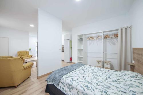 1 dormitorio con 1 cama y 1 silla en Apartamentos Avd Xerez, en Sevilla