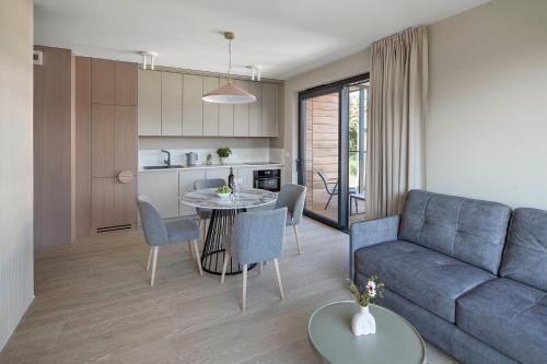 a living room with a blue couch and a table at Apartamenty na Półwyspie Wydma&Las in Jastarnia
