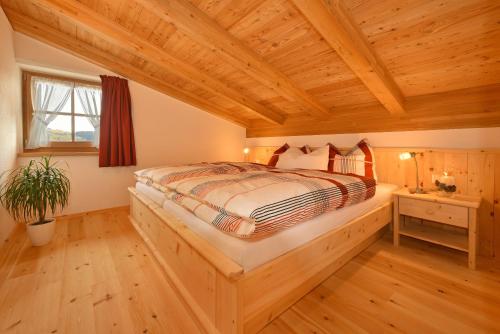 Cama en habitación con techo de madera en Tratterhof Apt Astjoch, en Vandoies