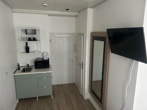 a small kitchen with a sink and a mirror at Pension Sonnenschein in Halle an der Saale