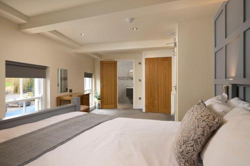 a bedroom with a large bed and a bathroom at Church House Inn, Stokenham in Kingsbridge