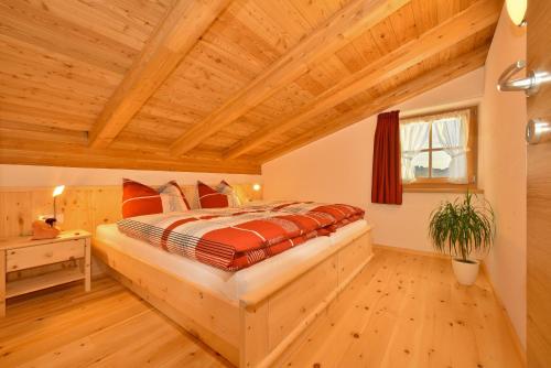 Tratterhof Apt Eidechsspitze في فاندويس: غرفة نوم بسرير وسقف خشبي