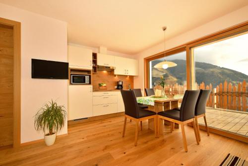 a kitchen and dining room with a table and chairs at Tratterhof Apt Eidechsspitze in Vandoies