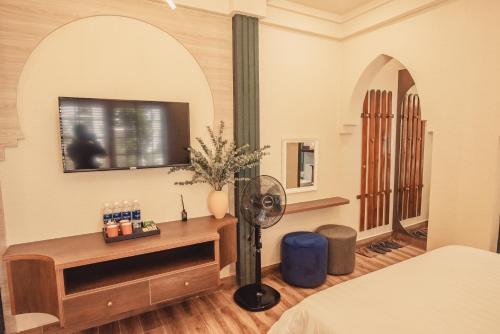 a hotel room with a bed and a fan at Villa Hoa Da in Da Lat