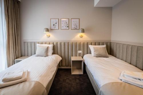 a hotel room with two beds and two lamps at Apartamenty Wolności 6 self check-in 24h in Poznań