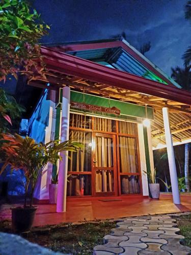 a building with a sign on the front of it at Turtle Island Cabana in Tangalle