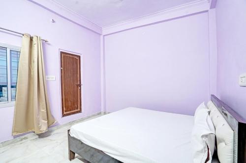 a white bedroom with a bed and a window at OYO Hotel Classic Villa in Kānpur