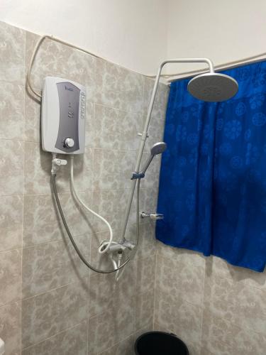 um chuveiro na casa de banho com uma cortina de chuveiro azul em Kimberly’s Hotel em Tamale