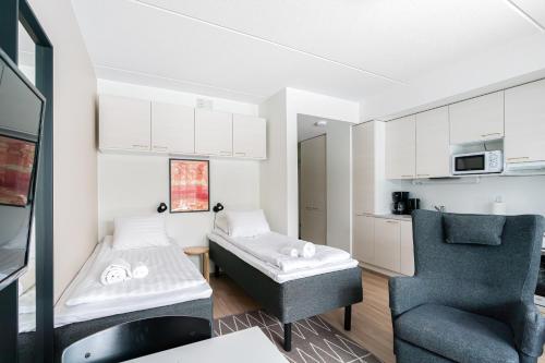 una piccola stanza con un letto e una sedia di Hiisi Homes Porvoo Toukovuori a Porvoo