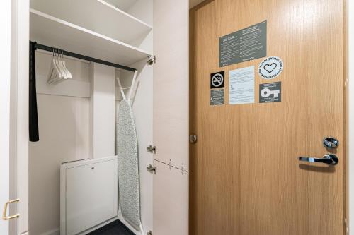 Una porta in una stanza con un orologio e dei documenti sopra di Hiisi Homes Porvoo Toukovuori a Porvoo