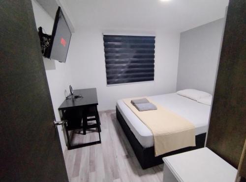 een kleine slaapkamer met een bed en een bureau bij casa entera con estacionamiento in Santiago