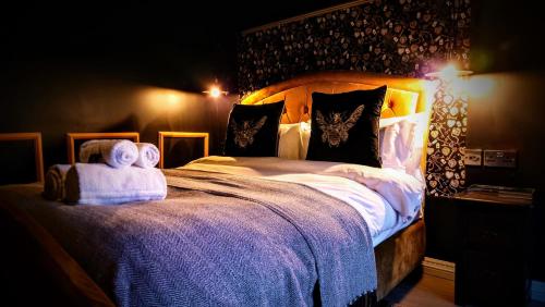 a bedroom with a large bed with towels on it at The Mad Hatter's Guestrooms in Oxford