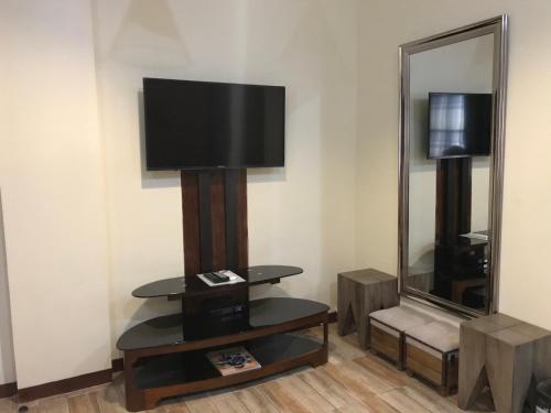 Habitación con TV y espejo. en Charos Dormitel en Dumaguete