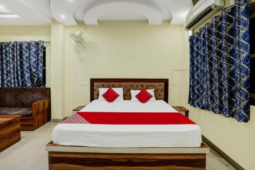 a bedroom with a large bed with red pillows at OYO Hotel Shubham in Rānchī