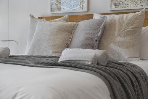 a bed with white sheets and pillows at Welgelegen 608 by Host Agents in Strand