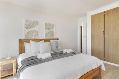 a white bedroom with a large bed with white pillows at Welgelegen 608 by Host Agents in Strand