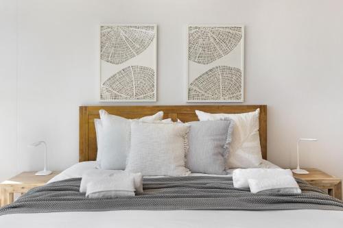 a bedroom with a bed with two pictures on the wall at Welgelegen 608 by Host Agents in Strand