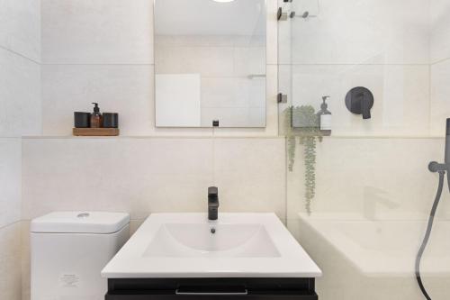 a white bathroom with a sink and a shower at Welgelegen 608 in Strand