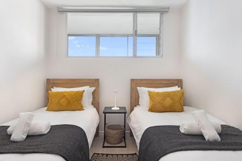 two twin beds in a room with a window at Welgelegen 608 by Host Agents in Strand