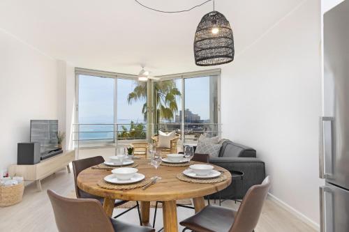 a dining room with a table and chairs and a kitchen at Welgelegen 608 by Host Agents in Strand