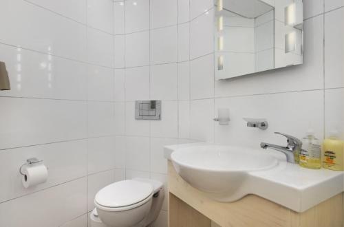 a white bathroom with a sink and a toilet at Pips Place 301 in Strand