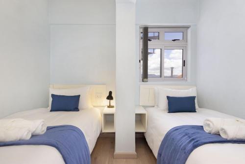 two twin beds in a room with a window at Pips Place 301 in Strand