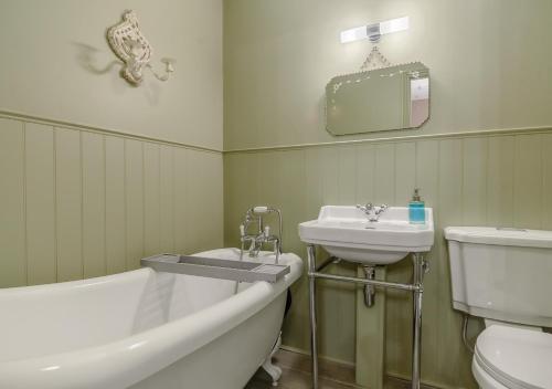 La salle de bains est pourvue d'une baignoire, d'un lavabo et de toilettes. dans l'établissement Little Broad, à Rollesby