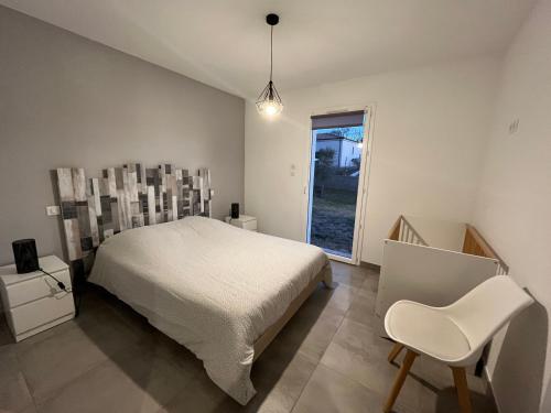 1 dormitorio con 1 cama, 1 silla y 1 ventana en Villa MaLou en Pradons