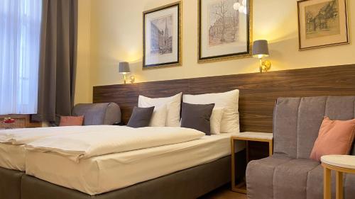 a hotel room with a bed and a chair at City Pension Stephansplatz I Self Check In in Vienna