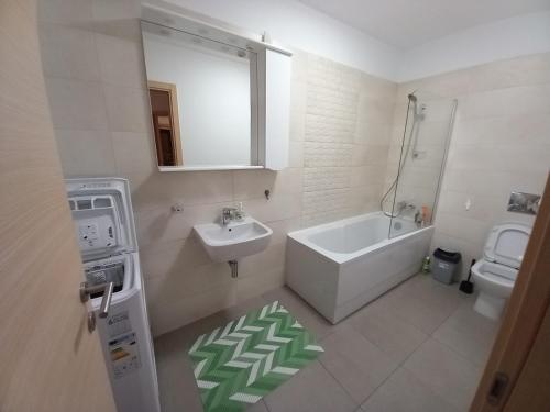 a bathroom with a sink and a tub and a toilet at Sofia & Natalia apartament in Bucharest