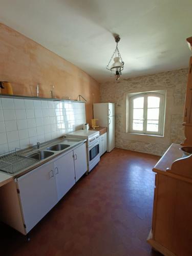 une grande cuisine avec des appareils électroménagers blancs et une fenêtre dans l'établissement Maggie 3 personnes, à Pont-Saint-Esprit