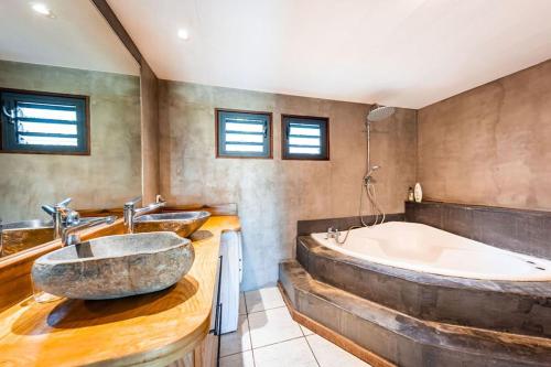 uma casa de banho com 2 lavatórios e uma banheira em Villa Ô Pieds Nus 180m2 4 chambres piscine jardin tropical parking privé em Saint-Leu