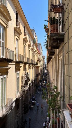 an alley with people walking down a street with buildings at Monastero Flat in Naples