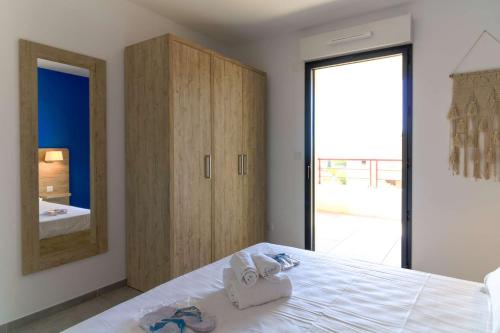 1 dormitorio con 1 cama con armario y espejo en SELECT' - T2 à Saint-Clair au Lavandou dans une résidence neuve avec piscine - 180SUD-B12, en Le Lavandou