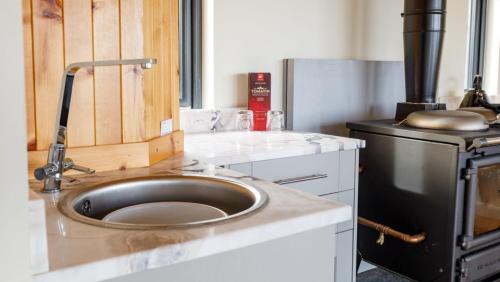 a kitchen with a sink and a stove at The Boathouse in Tomich