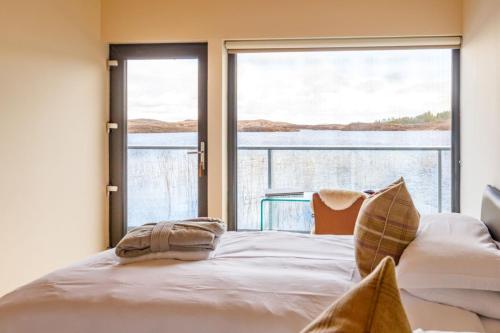a bedroom with a bed and a large window at The Boathouse in Tomich