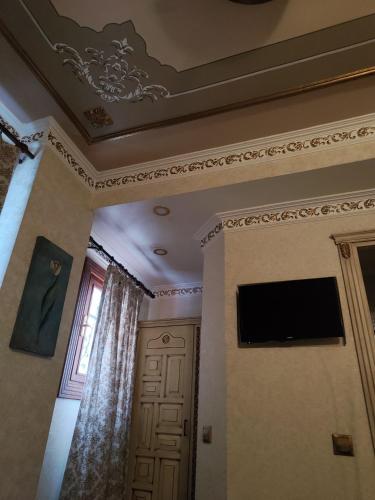 um quarto com tecto, televisão e porta em Nice Appart. no Cairo