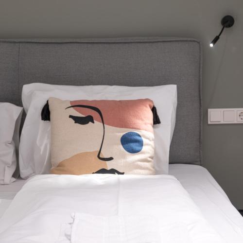 a bed with a pillow with a face on it at Mint@Naschmarkt Premium Apartments in Vienna