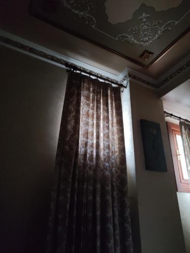 um quarto com uma cortina e uma janela em Nice Appart. no Cairo