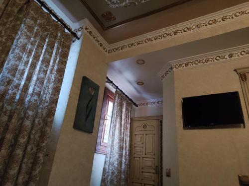 um quarto com uma televisão e uma janela com cortinas em Nice Appart. no Cairo