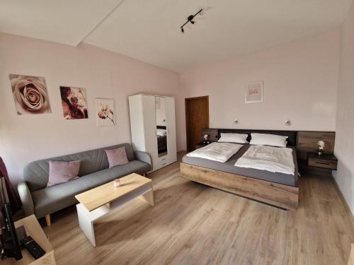 een slaapkamer met een bed en een bank bij Gästehaus Zur Post Spickermann in Xanten