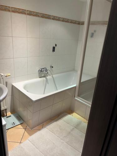 a bathroom with a bath tub and a sink at I. Ferienhaus Rathmannsdorfer in Bernburg