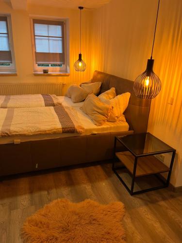 Schlafzimmer mit einem Bett mit Kissen und einem Tisch in der Unterkunft I. Ferienhaus Rathmannsdorfer in Bernburg