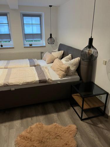 een slaapkamer met een bed met een tafel en 2 ramen bij I. Ferienhaus Rathmannsdorfer in Bernburg