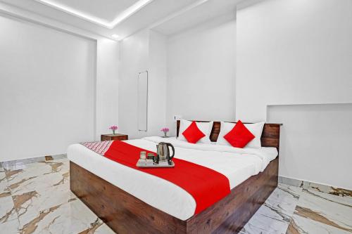 a bedroom with a large bed with red pillows at OYO Hotel Yashraj Inn in Sakardarā