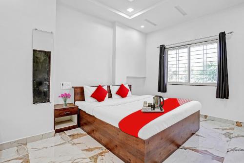 a bedroom with a large bed with red pillows at OYO Hotel Yashraj Inn in Sakardarā